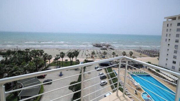 Vista de una playa con piscina y un edificio al frente.