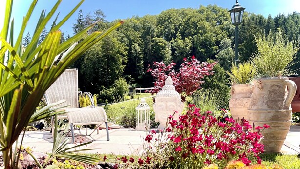 A garden with a Buddha statue, wicker chairs, and stone planters. - Guest Room, Enjoy the peaceful Bernese Seeland (Grossaffoltern)
