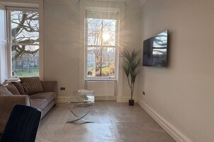 Un salon avec un canapé, une table basse et une plante en pot.