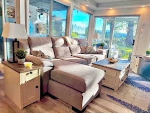 Una sala de estar moderna con un sofá modular, una mesita y un aparador.