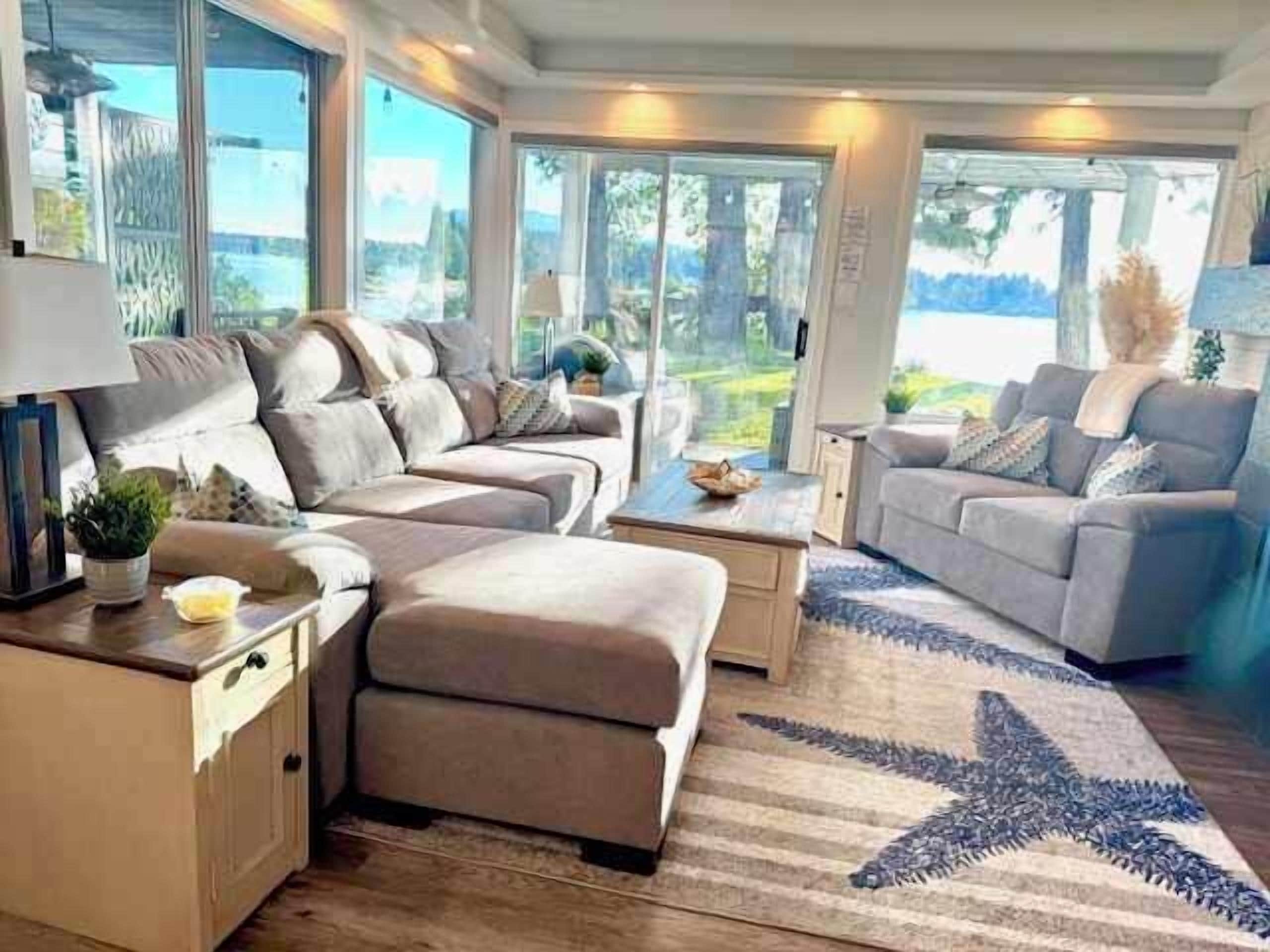 Ein modernes Wohnzimmer mit einer Eckcouch, einem Couchtisch und einem Teppich mit Sternenmuster.