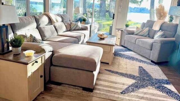 A modern living room with a sectional sofa, a coffee table, and a star-patterned rug. - Seascape Oasis - 2BDRM - Ocean View - Kitchen (Nanoose Bay)