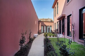 Stunning building with large windows and a visible roof, set amidst lush greenery.