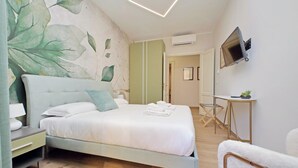 Un dormitorio moderno con cama, mesita de noche y televisor en la pared.