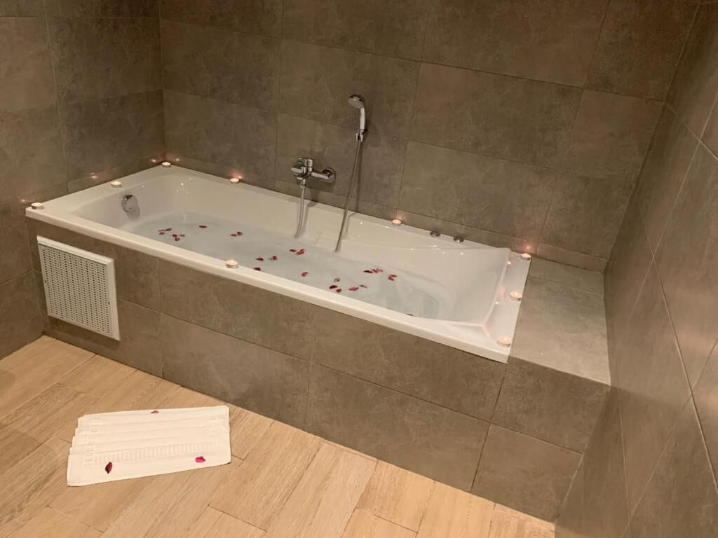 A modern bathroom with a freestanding bathtub, a showerhead, and a towel rack.