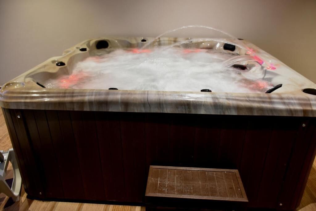 Un bain à remous avec une structure extérieure en bois et un panneau de commande intégré.
