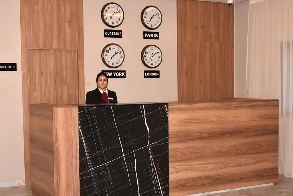 Una reception con orologi etichettati 'QUAZZANE', 'PARIGI', 'NEW YORK' e 'LONDRA'.