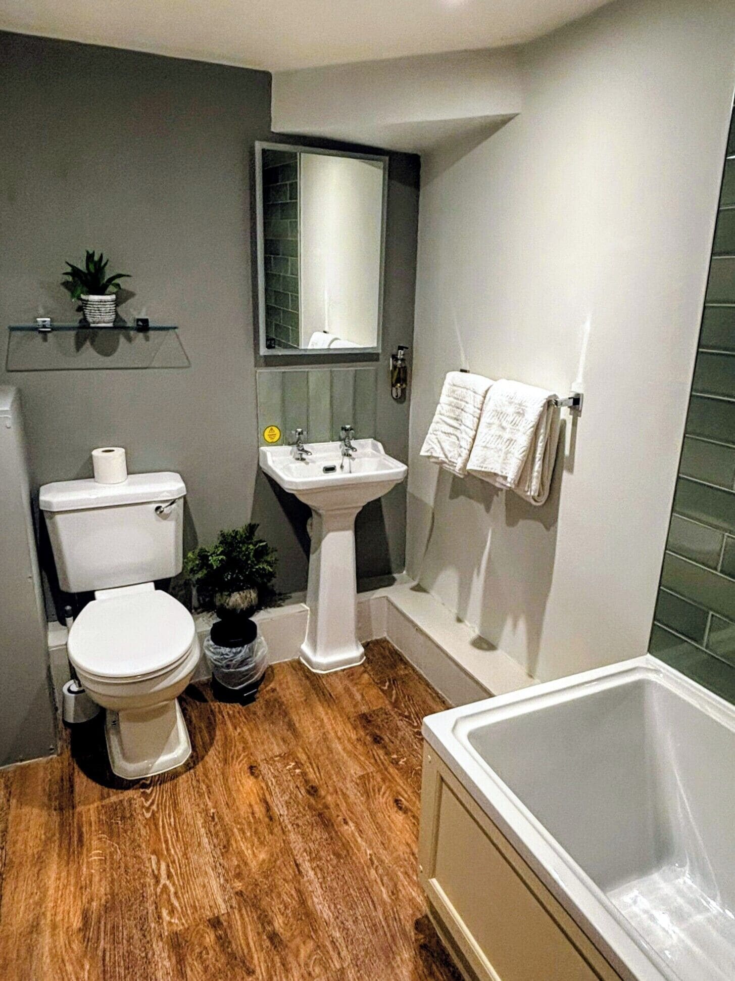 A modern bathroom with a toilet, sink, and bathtub.
