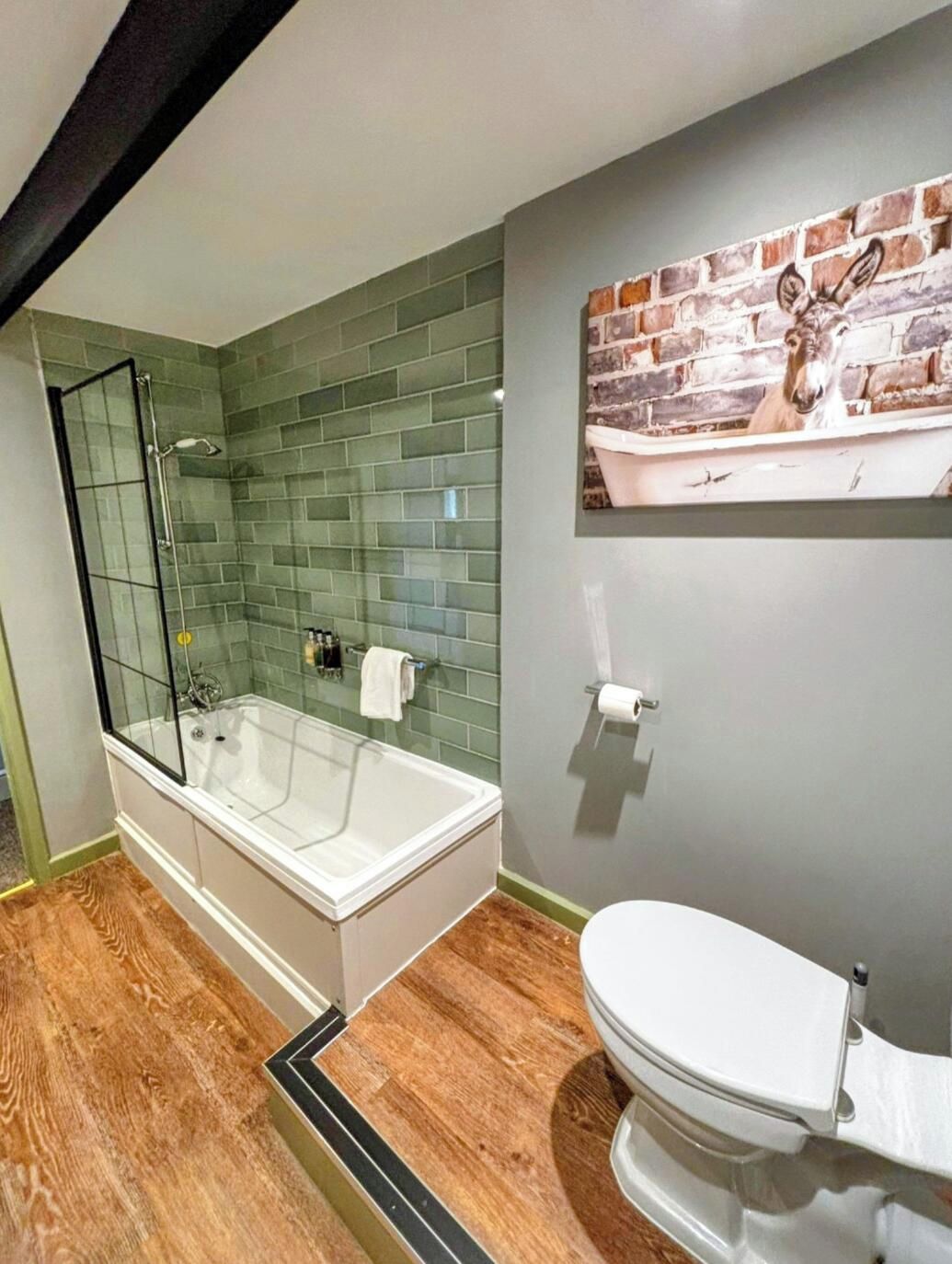 A bathroom with a glass-enclosed shower, a white bathtub, and a toilet.