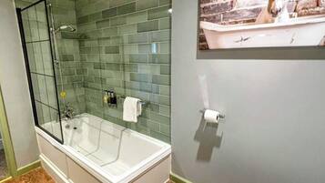 A bathroom with a glass-enclosed shower, a white bathtub, and a toilet.