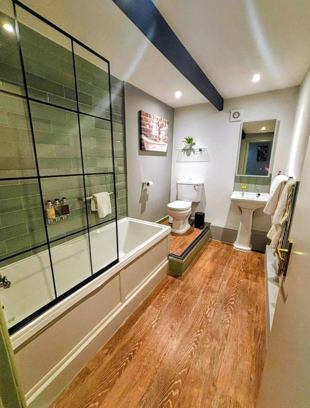 Une salle de bain moderne avec une douche à parois de verre, une baignoire, des toilettes et un lavabo.