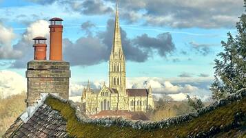 A historic building with a tall spire and a brick chimney.