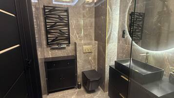 Chuveiro, toalhas de banho, sabonete, papel higiênico