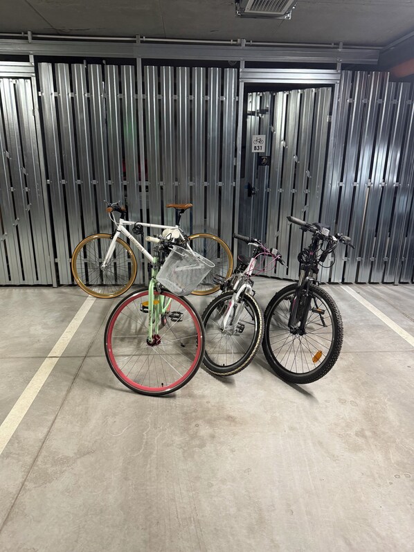 Un espace de stationnement où des vélos sont appuyés contre un mur en métal.