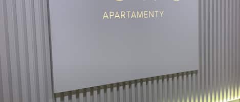 A sign for "MONO APARTMENT" with a modern design and illuminated strip lights.