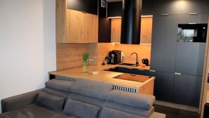 A modern kitchen with wooden cabinets, a built-in oven, and a sink.