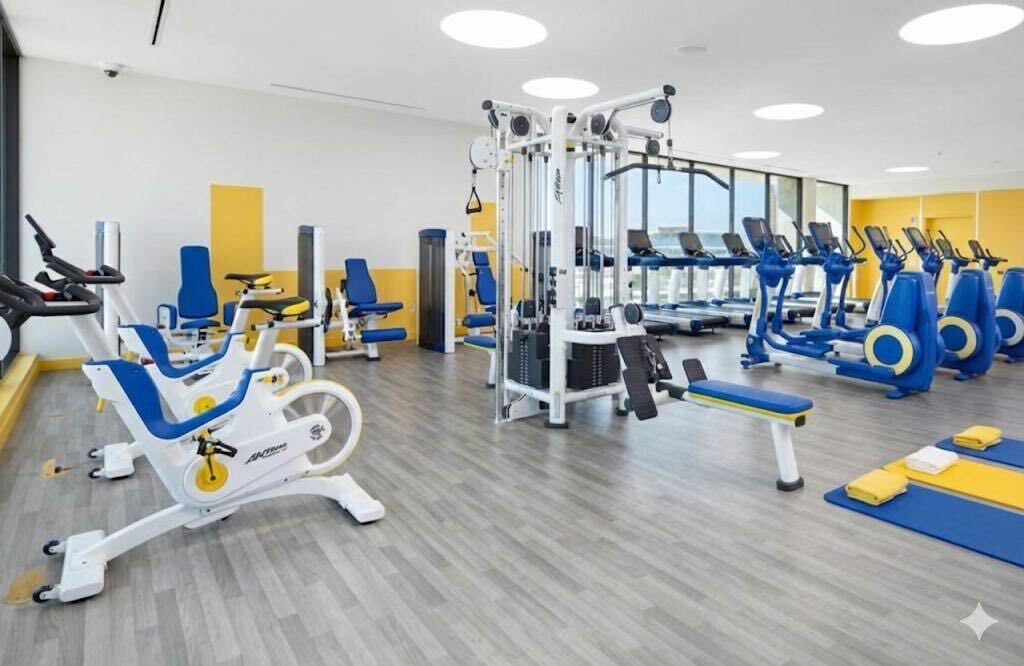 A gym with various exercise equipment, including treadmills, stationary bikes, and weight machines.
