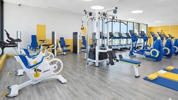 A gym with various exercise equipment, including treadmills, stationary bikes, and weight machines.