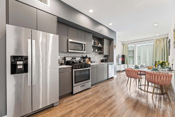 Gourmet kitchen equipped with premium stainless-steel appliances and a full-size refrigerator - perfect for home-style meals.
