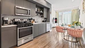 Eine moderne Küche mit grauen Schränken, Edelstahlgeräten und Holzboden.