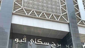 The entrance to the SKYVIEW TOWER with a modern design, featuring a geometric facade and a prominent entrance with glass doors. - Skyview Tower (Dubai)
