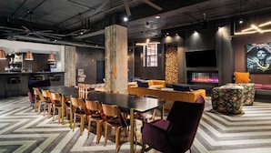 Un área de estar moderna con una mesa larga, sillas, una chimenea y un televisor.