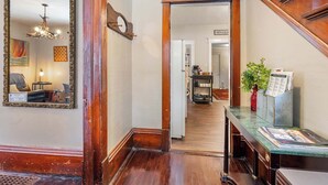 A hallway with a mirror, a wooden door, a small table with a vase, and a sign for 'Antenzo's'. - Downtown Sturgeon Bay Treasure (Sturgeon Bay)