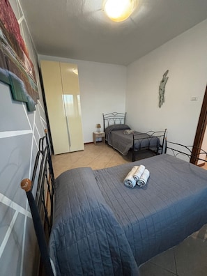Une chambre à coucher comprenant un lit, une table de chevet, une armoire et une horloge murale.