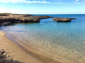 A beach with clear shallow waters, rocky formations, and a sandy shore. - NEW RENOVATED SHEPHERD HOUSE, near OSTUNI/PUGLIA, Barbecue, 2 adults, 1 child (Puglia)