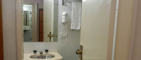 A bathroom with a sink, mirror, towel rack, and toilet.