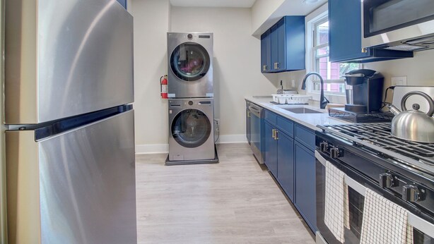 Een moderne keuken met roestvrijstalen apparatuur, een ingebouwde wasmachine en een gasfornuis.
