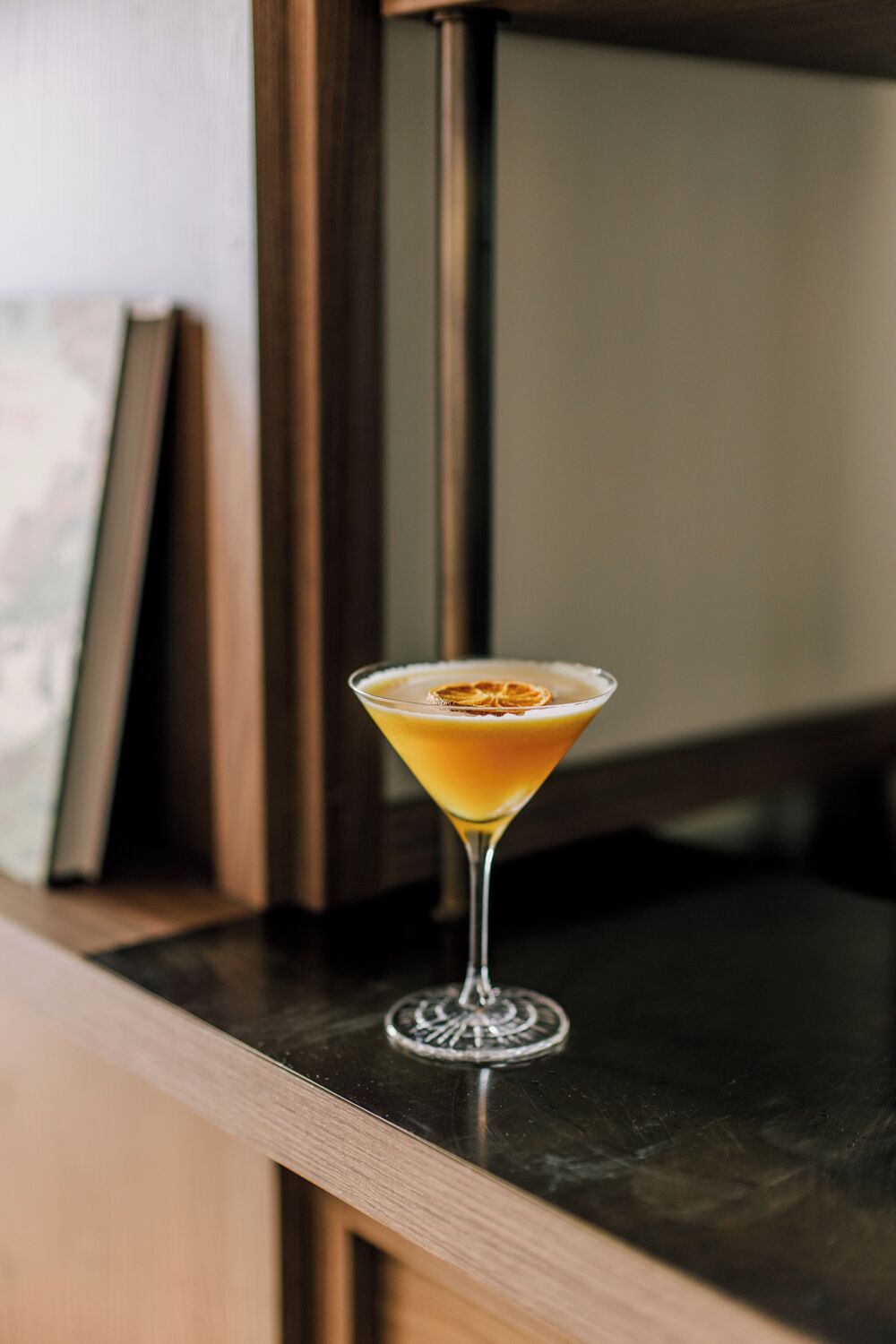 Una copa de martini con una guarnición sobre una barra.