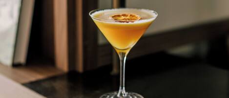 Una copa de martini con una guarnición sobre una barra.