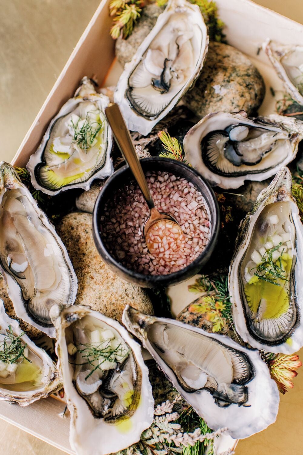 A box of oysters with a dipping sauce.