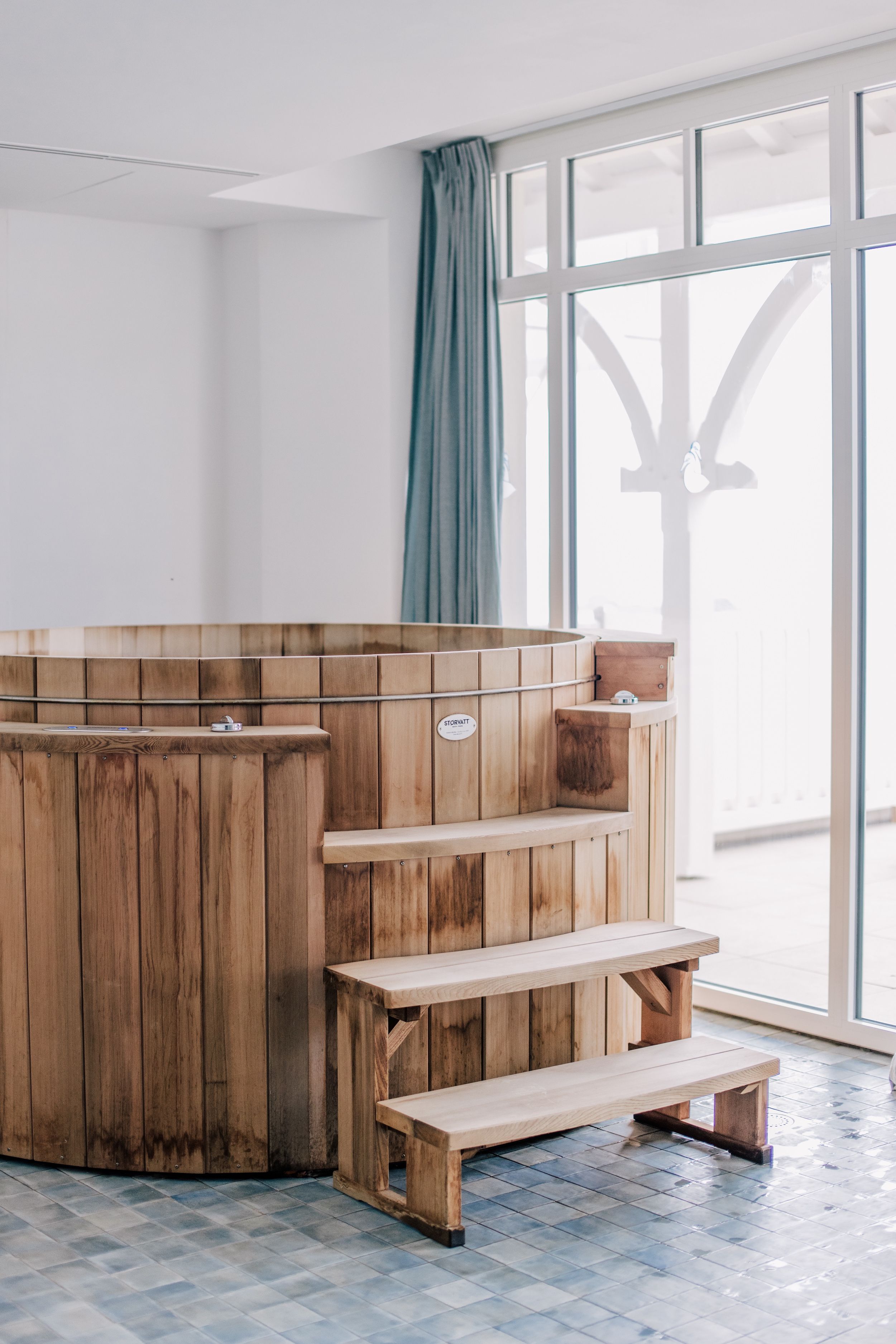 A wooden sauna with benches and a control panel.