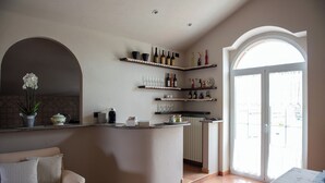 Eine Küche mit einer gebogenen Kochinsel, Weinfächern und Blick durch eine Glastür.