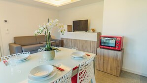 Eine moderne Küche mit Esstisch, Stühlen, einem roten Toaster und einem Topf mit einer Orchideenpflanze.