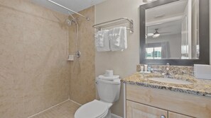 Un baño con ducha, inodoro y zona de lavamanos.