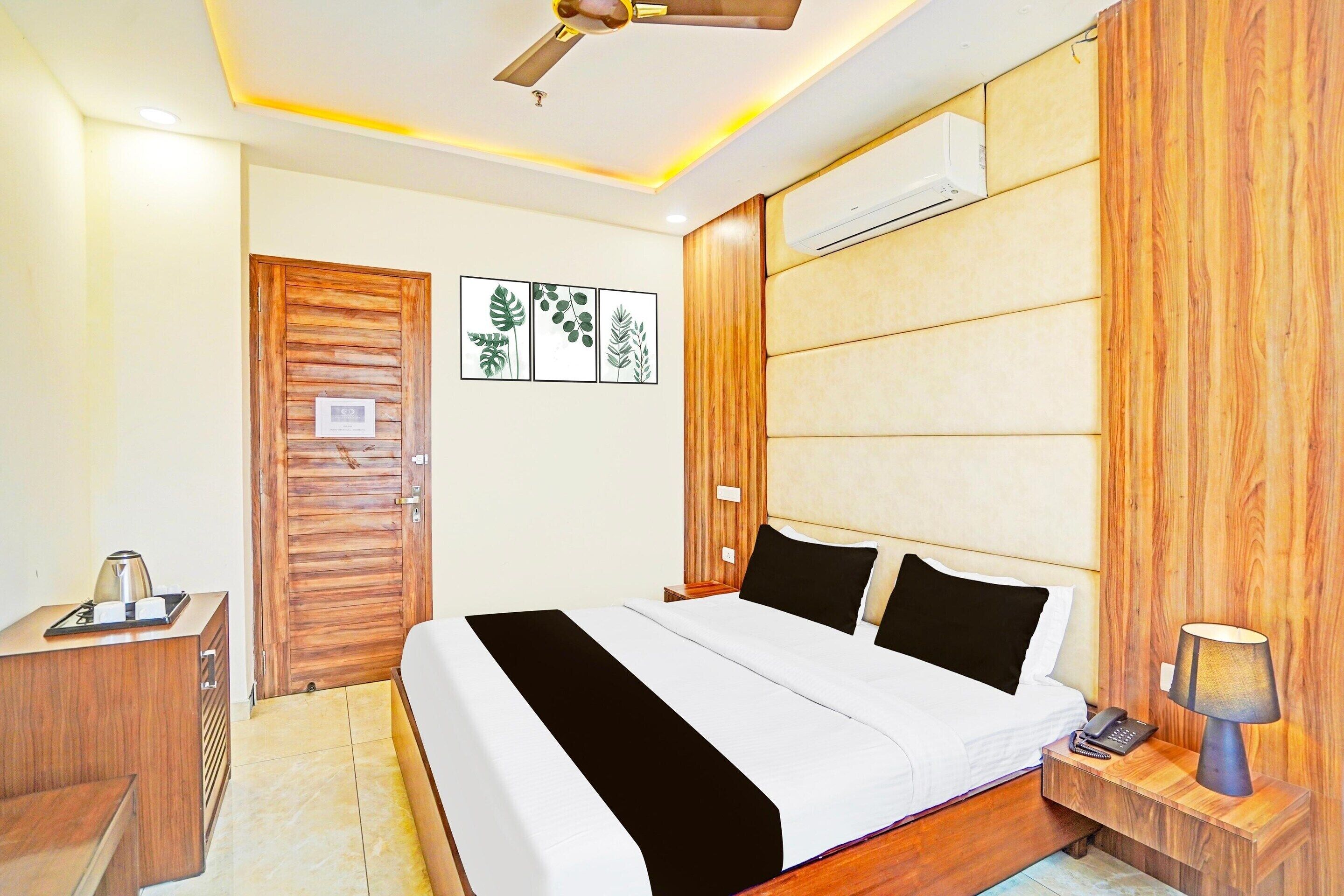 Une chambre d’hôtel équipée d’un lit, d’une table de chevet, d’une lampe et d’un ventilateur de plafond.