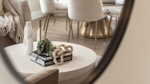 Una mesa redonda con un jarrón blanco, una planta en maceta y un libro titulado "IOT".