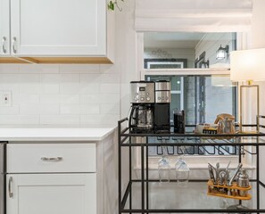Enjoy a sleek kitchen with a coffee station, white cabinetry, and city views.