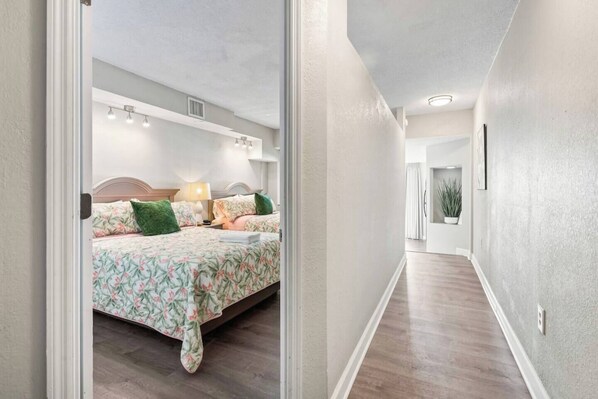 Una habitación de hotel con una cama, una mesita de noche, una lámpara y una ventana.