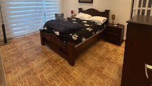 A bedroom with a bed, a nightstand, a dresser, a ceiling light, and a window with blinds. - IDEAL HOUSE TO REST, SWIMMING POOL, BBQ, WIFI, FULL AIRE (Sabanilla)