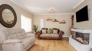 A living room with a beige sofa, a brown leather couch, and a fireplace.