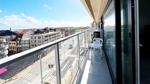 A balcony with a clear view of the cityscape, including buildings and a road. - Studio in Wenduine Near the Beach (De Haan)