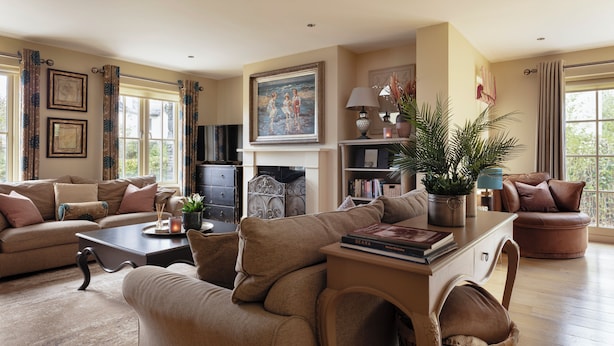 A cozy living room with a fireplace, comfortable seating, and a bookshelf.