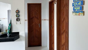 Un pasillo con una puerta de madera, un letrero en la pared y un estante con objetos decorativos.
