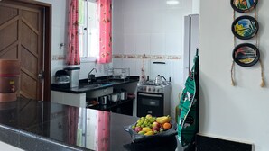 Una cocina con estufa a gas, horno y un frutero sobre la encimera.