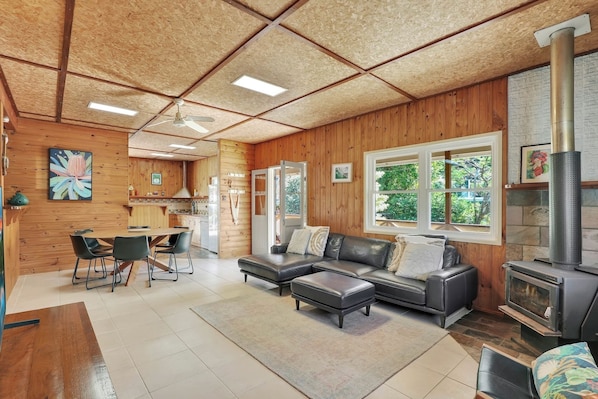 Ein gemütliches Blockhaus-Interieur mit Essbereich, einer Couch und einem Kamin.