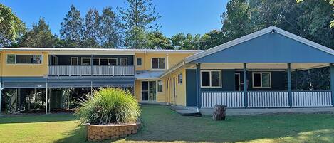 A two-story house with a covered porch and a small garden area.